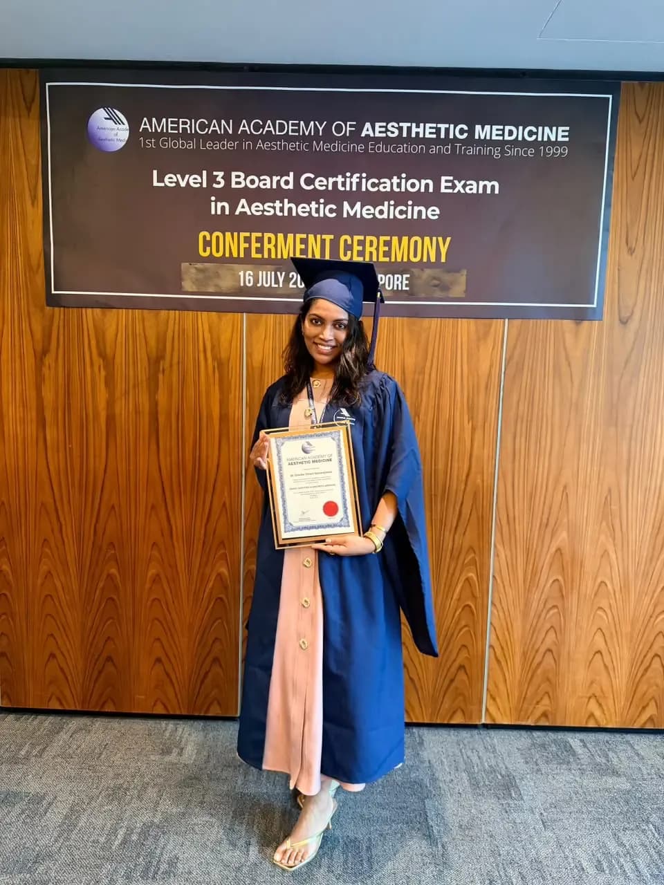 Dr Dinelka Yohani Samarajeewa in cap and gown at the American Academy of Aesthetic Medicine Level 3 Board Certification conferment ceremony in Singapore, 16 July 2026